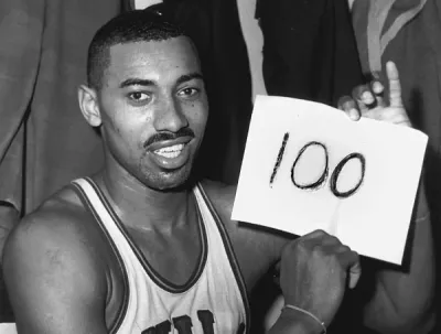 Wilt Chamberlain holding a &ldquo;100&rdquo; sign after scoring 100 points in an NBA game